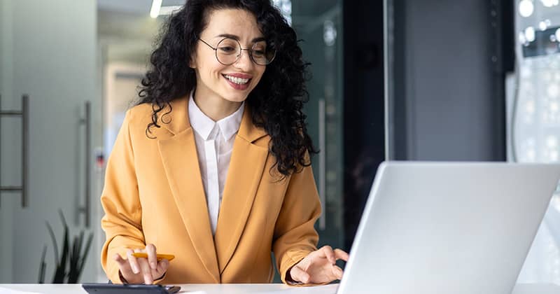 Happy woman using calculator