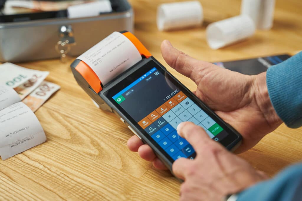 Technician processing payments using a device and portable printer in the field for efficient billing.