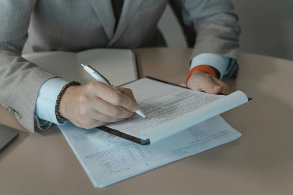 Person reviewing and signing documents, related to home improvement contractor registration.